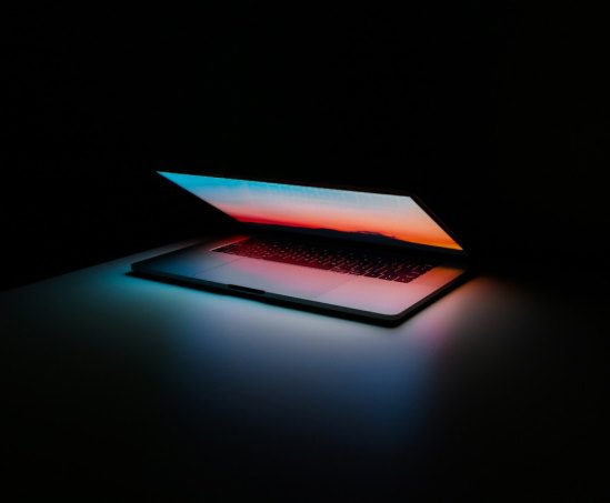een laptop in het donker met vele kleuren